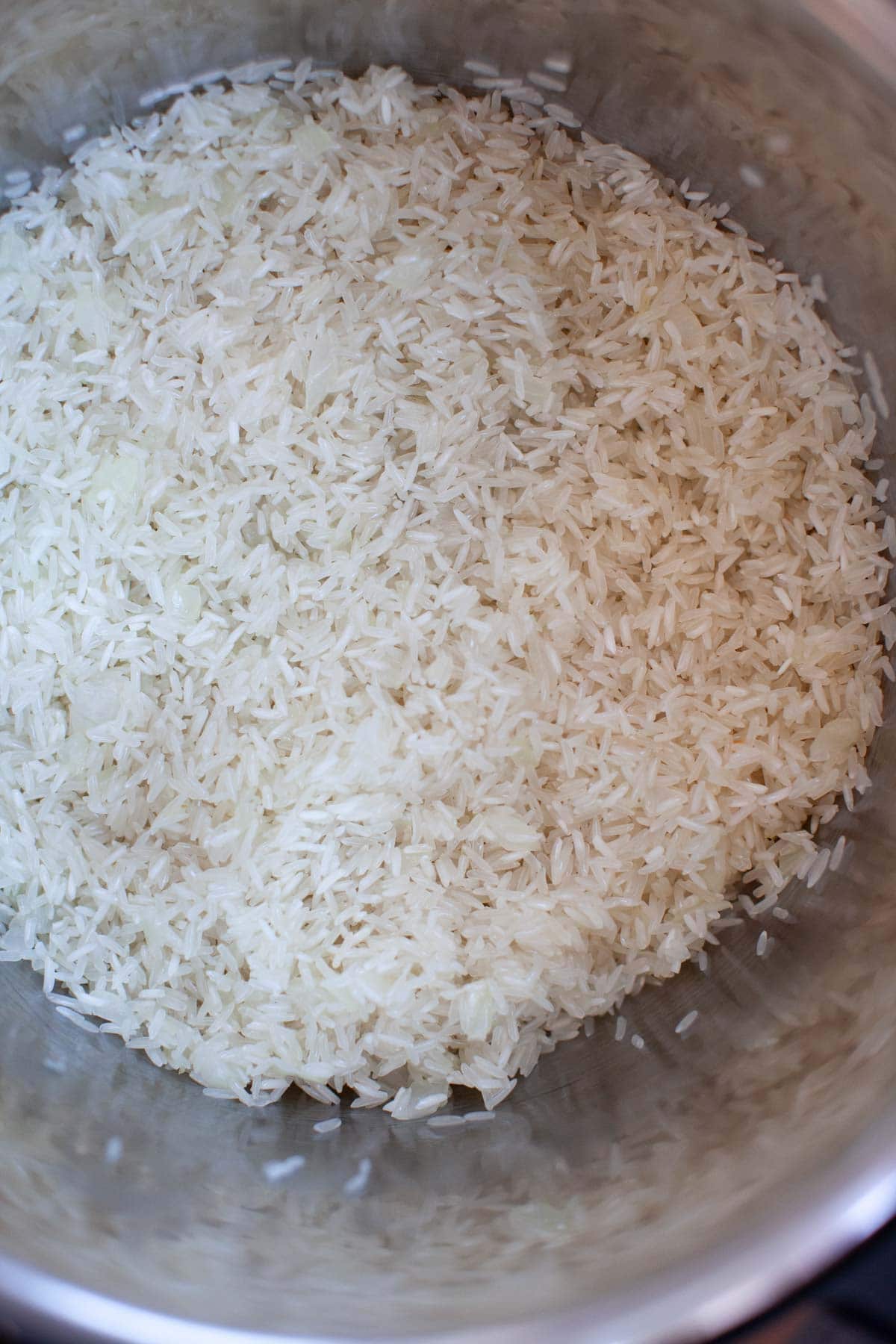 Rice and onion mixture in an Instant Pot.