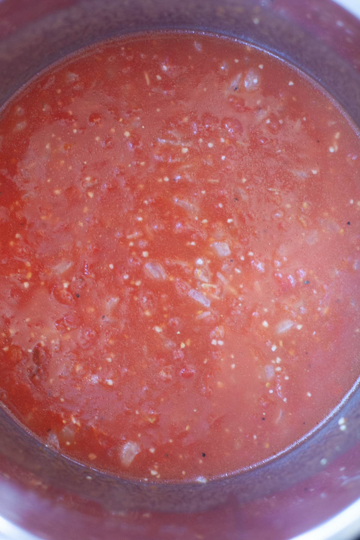 A pot of tomato sauce on a stove top.