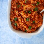 Instant pot Mexican rice in a white dish with a spoon.