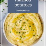 A bowl of creamy mashed potatoes topped with melted butter and chives, with a title text saying "instant pot mashed potatoes" from joyfullymad.com adorned with fruit salad dressings.