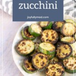 A plate of browned, sautéed zucchini rounds is displayed with a text overlay reading "Joyfully Sauteed Zucchini" and the website "joyfullymad.com" above. A striped cloth is in the background.