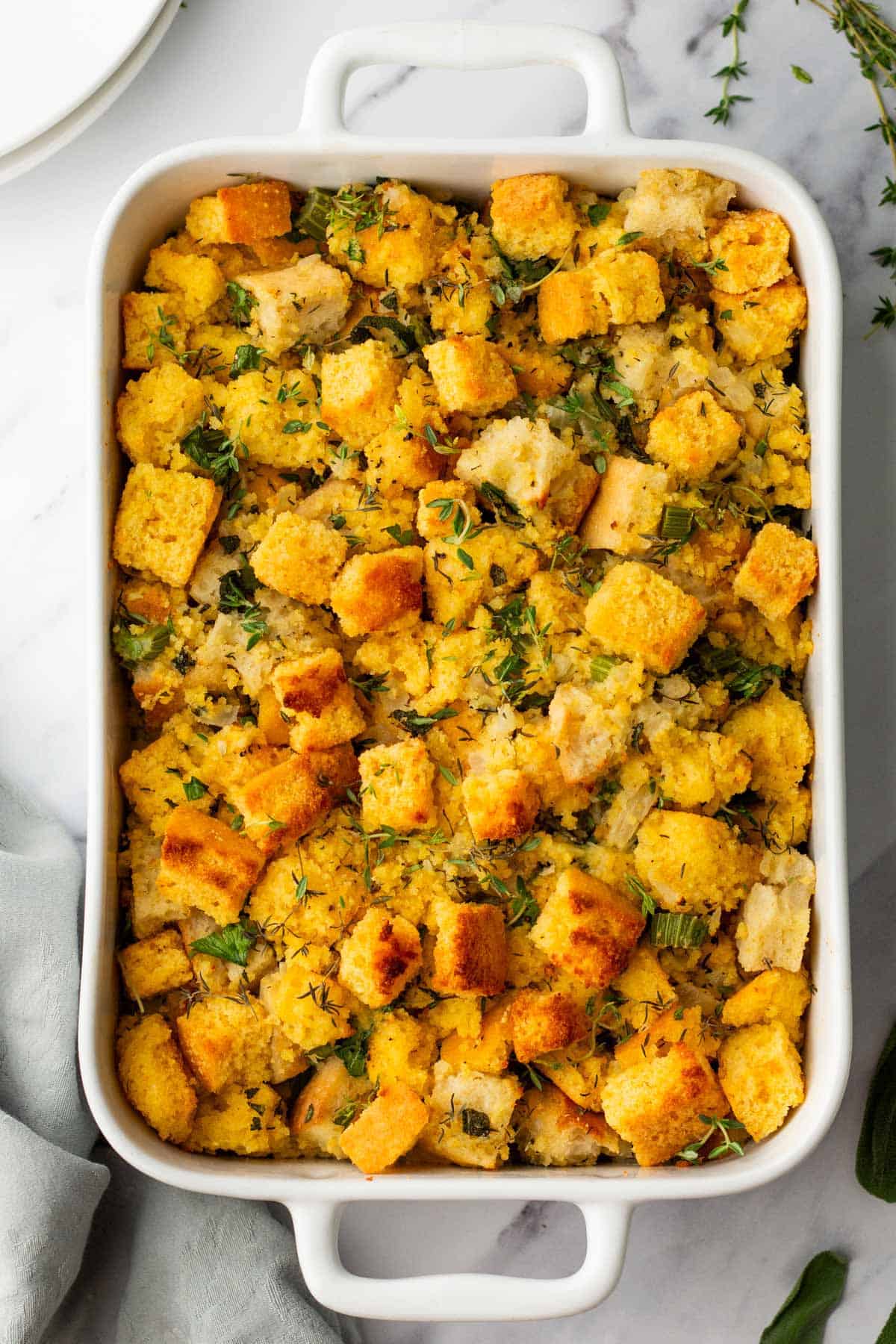 Baked cornbread stuffing filled with golden brown bread cubes, herbs, and vegetables.