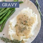 A plate of mashed potatoes topped with gravy and garnished with herbs, sits invitingly next to fresh green beans. In the background, a textile peeks through, hinting at cozy mornings of apple pancakes shared around the table.