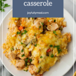 A plate of chicken wild rice casserole garnished with herbs, showcasing tender pieces of chicken, flavorful wild rice, and gooey melted cheese.