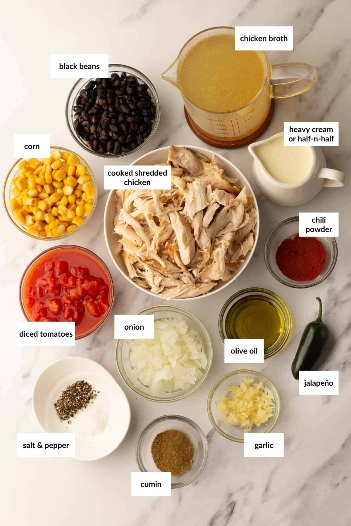 Ingredients for a dish including black beans, chicken broth, corn, shredded chicken, heavy cream, chili powder, diced tomatoes, onion, olive oil, jalape&ntilde;o, salt, pepper, cumin, and garlic.