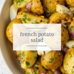 A bowl of French potato salad with chopped herbs and onions, seasoned with pepper, offers a savory contrast to the rich sweetness of chocolate buttercream frosting.