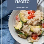 A bowl of vegetable risotto with zucchini and tomatoes, placed on a plate next to a blue cloth, with the text "vegetable risotto" above—perfect alongside a fresh blender salsa for a vibrant meal.
