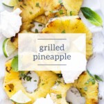 Sliced grilled pineapple with lime wedges, mint leaves, and dollops of cream on a white plate, accented by a honey dipper in the corner. Text overlay reads "grilled pineapple.