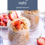 Two jars of peanut butter overnight oats topped with strawberries and peanut butter, extra strawberries in the background. Perfect to pair with a blueberry banana smoothie. Text overlay reads "peanut butter overnight oats.