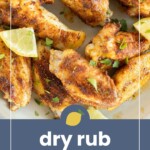 A plate of flavorful dry rub wings garnished with chopped herbs and lime wedges, with the text "dry rub wings" at the bottom.
