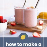 Two glass jars filled with pink fruit smoothies and metal straws are on a cutting board, surrounded by fresh strawberries and bananas. A text overlay reads "how to make a fruit smoothie.