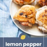 A white plate with cooked, golden brown chicken thighs sits on a blue cloth. Text below reads, "lemon pepper chicken thighs," with a small lemon icon above the text.