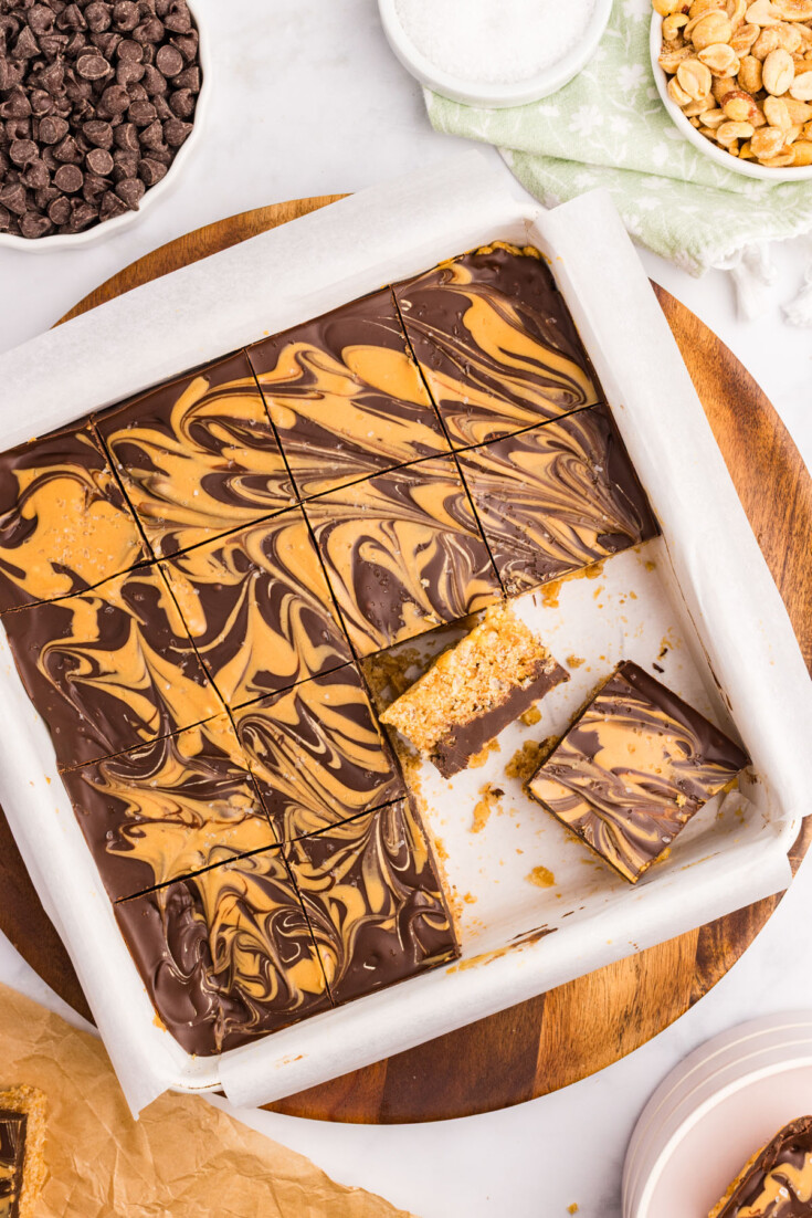 A brown and white cake with a slice cut in half.