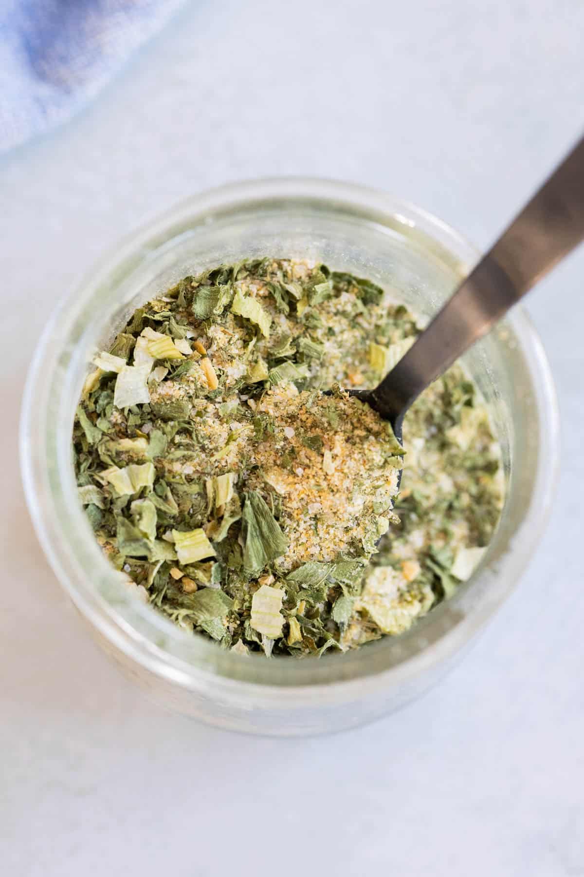 A spoon in a jar of ranch seasoning.