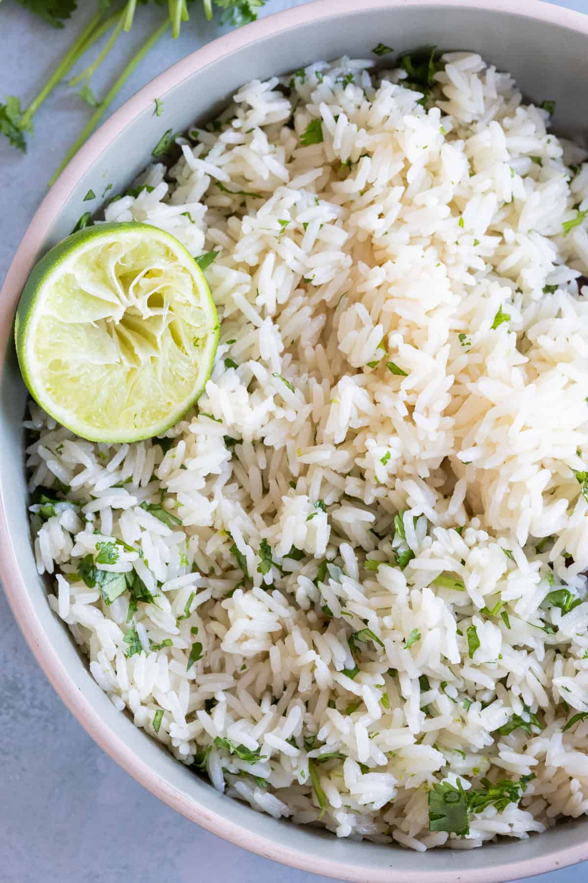 A bowl of cilantro lime rice garnished with a halved lime.