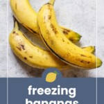 Three ripe bananas with brown spots on a light surface, above text that reads "freezing bananas before they go bad.