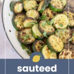 Sliced sautéed zucchini with browned edges in a white pan, garnished with parsley, and a wooden spoon in the background. Text reads “sautéed zucchini” with a lemon graphic.