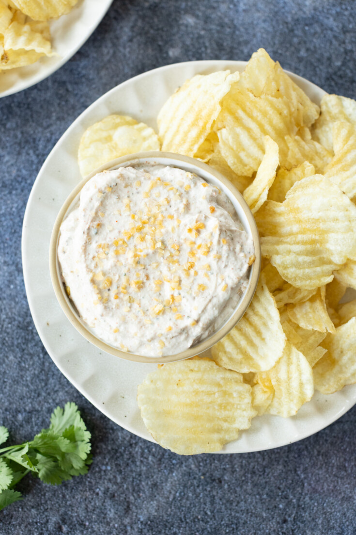 A bowl of creamy dip topped with seasoning.