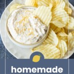 A bowl of onion dip sits on a plate surrounded by ridged potato chips, with the text “homemade onion dip” displayed at the bottom of the image.